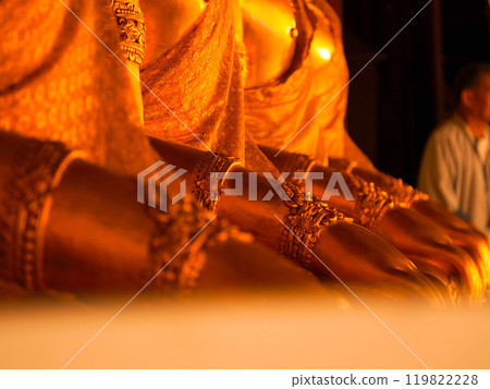 Close-up of details of golden Buddha hands arranged in a row in a Thai temple. Close-up of details of golden Buddha hands arranged in a row in a Thai temple. 119822228