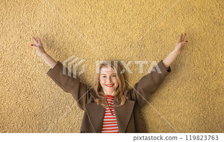 woman stands confidently, her smile and raised arms embodying self-assurance and pride, joy of freedom and happiness woman stands confidently, her smile and raised arms embodying self-assurance and pride, joy of freedom and happiness 119823763