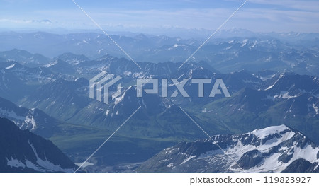 Tranquil Lake With Lush Green Forest, Snow-Capped Mountain, Blue Sky And White Clouds 119823927