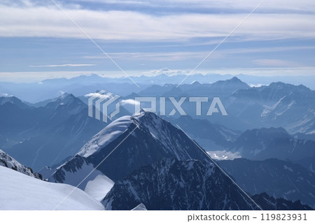Tranquil Lake With Lush Green Forest, Snow-Capped Mountain, Blue Sky And White Clouds 119823931