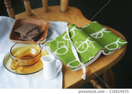 下午茶時間，閱讀一本帶有手工製作書籍封面的平裝書、餅乾和茶 119824035