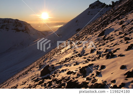 Breathtaking Rocky Mountain Slope Bathed in Morning Sunlight with Snow-Capped Peaks Nearby 119824180