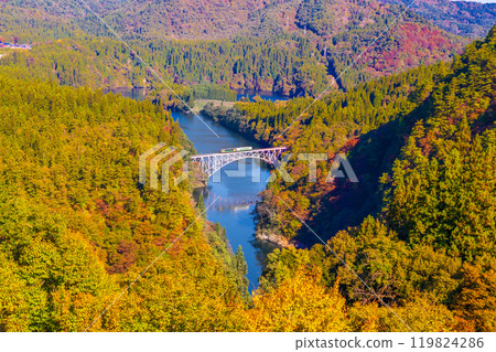 穿越只見川大橋和秋葉覆蓋的山脈的機車 119824286