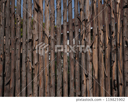 A wooden handmade fence from natural logs in a public park. A wooden handmade fence from natural logs in a public park. 119825902