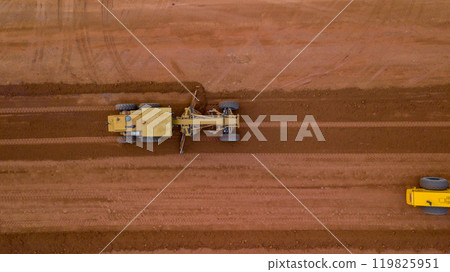 Aerial view road motor grader flatting dirt road surface, Motor grader road construction grader industrial machine on construction site of new road, Mortor grader on work. Aerial view road motor grader flatting dirt road surface, Motor grader road construction grader industrial machine on construction site of new road, Mortor grader on work. 119825951