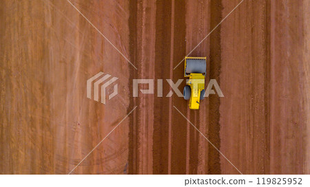 Aerial view road motor grader flatting dirt road surface, Motor grader road construction grader industrial machine on construction site of new road, Mortor grader on work. 119825952