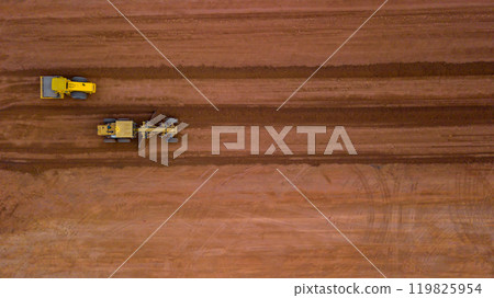 Aerial view road motor grader flatting dirt road surface, Motor grader road construction grader industrial machine on construction site of new road, Mortor grader on work. 119825954