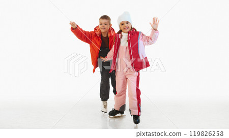 Happy young boy and girl, brother and season wearing red winter jackets, enjoying ice skating, isolated on white background Happy young boy and girl, brother and season wearing red winter jackets, enjoying ice skating, isolated on white background 119826258