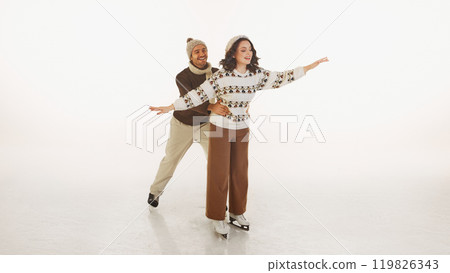 Couple dressed in warm sweaters and hats having fun on ice rink, enjoying skating together isolate and white background Couple dressed in warm sweaters and hats having fun on ice rink, enjoying skating together isolate and white background 119826343