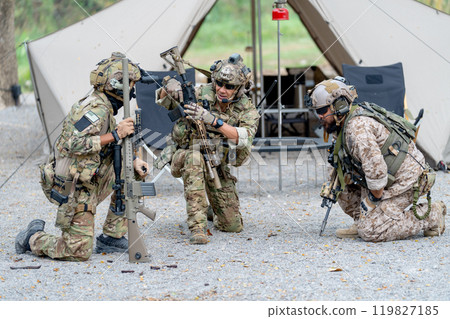 Group of militaries or soldiers discuss and stay in front of tent during outdoor practice. Group of militaries or soldiers discuss and stay in front of tent during outdoor practice. 119827185