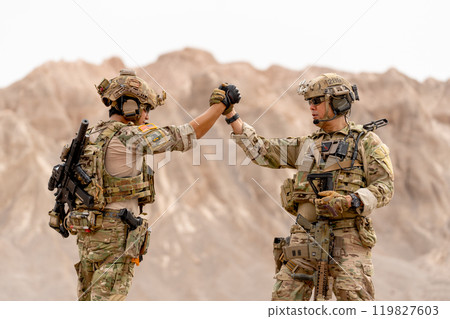 Two of soilders or militaries with war suit and gun holding hands together during outdoor practice. 119827603