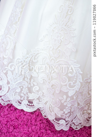 Delicate White Lace Embroidery on a Soft Fabric Background During a Garment Fitting. Delicate White Lace Embroidery on a Soft Fabric Background During a Garment Fitting. 119827866