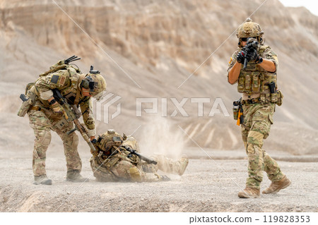 One of Military or soldier try to pull member of his team along the way to escape the danger and protect by the other one point gun to front upper to enemy. 119828353