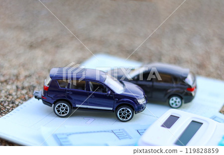 Model car and calculator are on notebook with blur background. Planning of saving for buying car, car loan and car insurance concept. Model car and calculator are on notebook with blur background. Planning of saving for buying car, car loan and car insurance concept. 119828859
