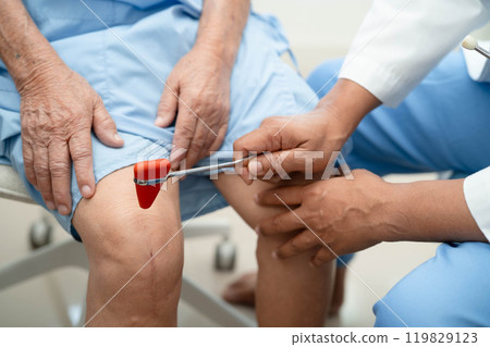 Asian doctor knock on knee reflex nerve for check and treatment senior patient in hospital. Asian doctor knock on knee reflex nerve for check and treatment senior patient in hospital. 119829123