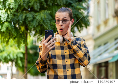Excited happy joyful winner man using smartphone looking at screen, wow emotion good message news Excited happy joyful winner man using smartphone looking at screen, wow emotion good message news 119829307
