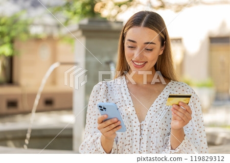 Woman using credit bank card smartphone while transferring money, purchases online shopping, order Woman using credit bank card smartphone while transferring money, purchases online shopping, order 119829312