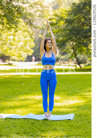 Flexible young woman doing yoga stretching exercises on mat, workout, gymnastic domestic fitness 119829326