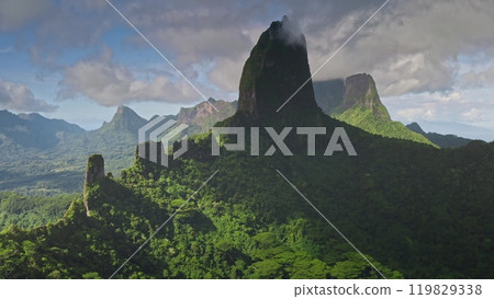 Dramatic landscape rugged peaks and ridges of Moorea's ancient volcanic mountains, now covered in dense rainforest. Remote wild nature paradise, exotic summer luxury travel. Aerial view drone flight 119829338