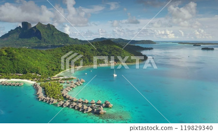 Aerial drone footage of tropical Bora Bora island in French Polynesia, famous overwater bungalow resorts and turquoise lagoon with a sailboat yacht. Popular tourist destination, exotic summer travel Aerial drone footage of tropical Bora Bora island in French Polynesia, famous overwater bungalow resorts and turquoise lagoon with a sailboat yacht. Popular tourist destination, exotic summer travel 119829340