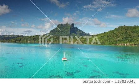 Aerial view of catamaran sailing turquoise lagoon, with iconic mountain Otemanu towering over Bora Bora island in the background. Remote wild nature paradise, exotic summer luxury travel. Drone flight Aerial view of catamaran sailing turquoise lagoon, with iconic mountain Otemanu towering over Bora Bora island in the background. Remote wild nature paradise, exotic summer luxury travel. Drone flight 119829345