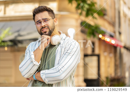 Sad unhappy young man thinks over life concerns, suffers from unfair situation on urban city street Sad unhappy young man thinks over life concerns, suffers from unfair situation on urban city street 119829549