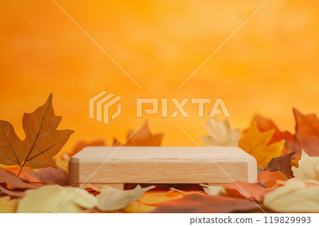 Empty wooden product stand with autumn fallen leaves on orange background. Wood podium for product display, promotion. Fall concept, autumn setting to showcase products, sale 119829993