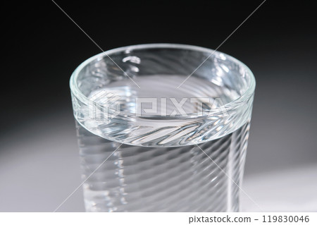 Glass of clean filtered water on white background with beautiful glare. 119830046