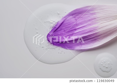 A drop of serum on a purple flower petal. 119830049