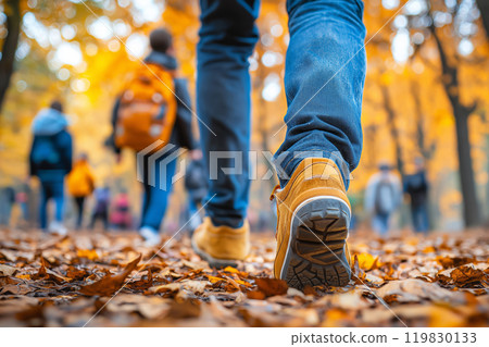 Family walking in autumn park. Tourists walking in the autumn forest. Feet close-up. Traveling, family vacations and fall seasonal holidays concept 119830133