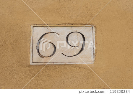 Elegant number sixty nine on doorway number panel 119830284