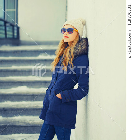 Fashion pretty blonde woman wearing a jacket and hat in winter city 119830331