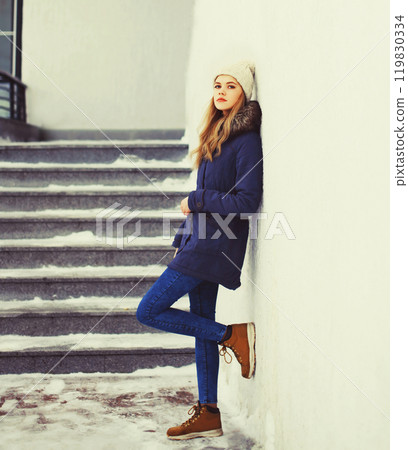 Fashion pretty cool girl wearing jacket and hat in winter city 119830334