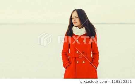 Fashion beautiful young woman wearing a red jacket in winter field Fashion beautiful young woman wearing a red jacket in winter field 119830351