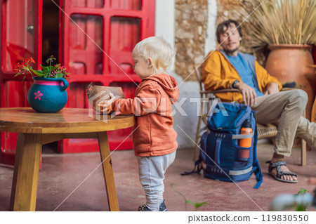 Father and his son tourists in a colonial house in San Cristobal de las Casas, Mexico. Cultural exploration, architecture, and travel experience concept Father and his son tourists in a colonial house in San Cristobal de las Casas, Mexico. Cultural exploration, architecture, and travel experience concept 119830550