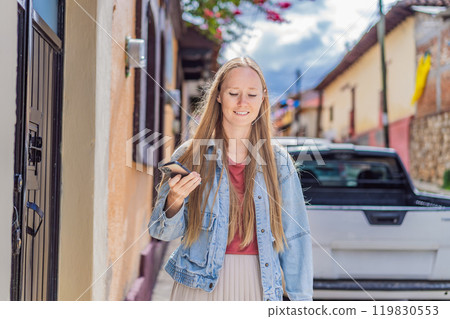 Female tourist walks through the colonial streets San Cristobal de las Casas, Mexico. Cultural exploration, architecture, and travel experience concept Female tourist walks through the colonial streets San Cristobal de las Casas, Mexico. Cultural exploration, architecture, and travel experience concept 119830553