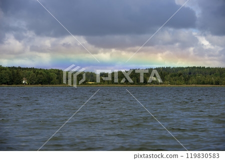 a serene and peaceful natural landscape featuring a calm lake under an overcast sky 119830583