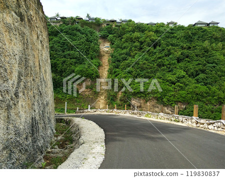 The road runs along the cliff with a beautiful view of the ocean. The road runs along the cliff with a beautiful view of the ocean. 119830837