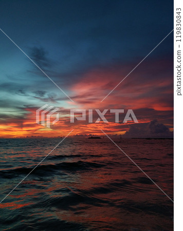 Calm ocean waves on a deserted beach with black volcanic sand. Beautiful sunset on the horizon Calm ocean waves on a deserted beach with black volcanic sand. Beautiful sunset on the horizon 119830843