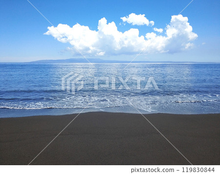 Ocean waves on a deserted beach with black volcanic sand. 119830844