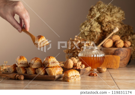 Baklava with walnuts and honey on a beige background. 119831174