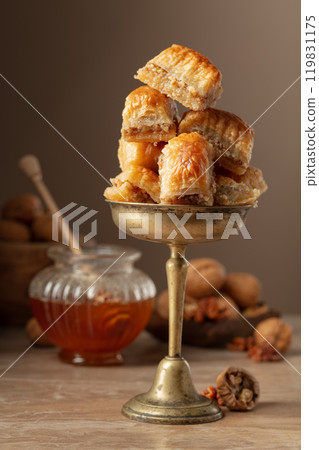 Baklava with walnuts and honey on a beige background. 119831175