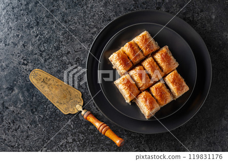 Baklava with walnuts on a blackstone table. 119831176