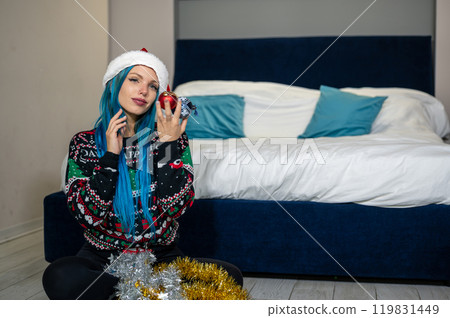 Portrait of beautiful caucasian hipster woman in Christmas clothes. Posing looking at camera holding colorful balls. Beauty, Christmas holidays, positivity 119831449