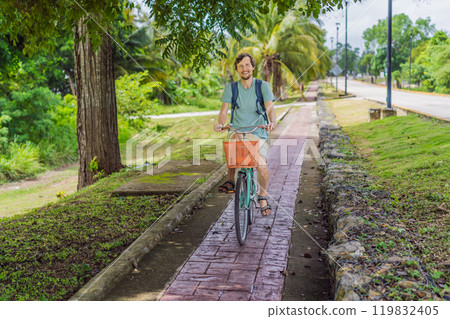 Man tourist cycling through the charming village of Bacalar, Mexico. Quintana Roo travel, scenic bike paths, and eco-friendly exploration concept 119832405