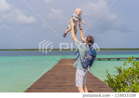 Father with his toddler son exploring wooden pier over the turquoise waters of Bacalar Lake, Mexico. Peaceful tropical travel destination concept Father with his toddler son exploring wooden pier over the turquoise waters of Bacalar Lake, Mexico. Peaceful tropical travel destination concept 119833109