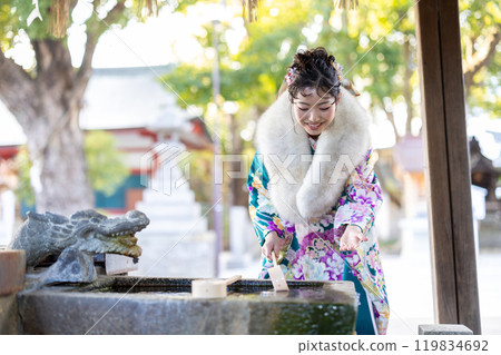 一位身著傳統服裝的年輕女子在神社祈禱 一位身著傳統服裝的年輕女子在神社祈禱 119834692