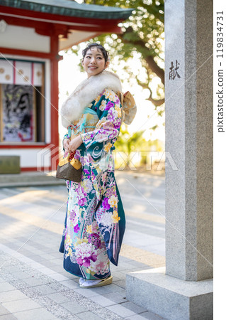 一位身著傳統服裝的年輕女子在神社祈禱 119834731