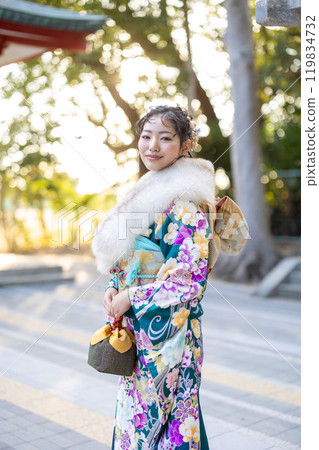 A young woman in formal attire praying at a shrine A young woman in formal attire praying at a shrine 119834732