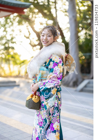 A young woman in formal attire praying at a shrine A young woman in formal attire praying at a shrine 119834733